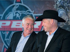 Oilers Entertainment Group CEO Bob Nicholson laughs with Professional Bull Riders CEO Sean Gleason during a press conference announcing a new partnership between the two organizations at EPCOR Tower, in Edmonton Aug. 3, 2016.
