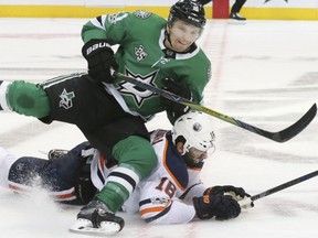 Dallas Stars left wing Antoine Roussel (21) and Edmonton Oilers center Ryan Strome (18) fall to the ice during the first period of an NHL hockey game in Dallas, Saturday, Nov. 18, 2017.