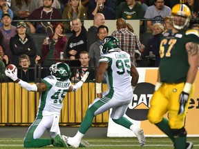 Saskatchewan Roughriders Kacy Rodgers II (45) celebrates touchdown with Antonio Longino (95) after his interception against the Edmonton Eskimos during CFL action at Commonwealth Stadium in Edmonton, August 25, 2017.