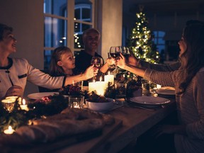 Family toasting with wine in a christmas dinner at home in the living room. Happy family celebrating christmas together at home.

Model and Property Released