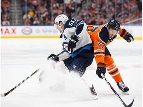 Oscar Klefbom #77 of the Edmonton Oilers battles against Mark Scheifele #55 of the Winnipeg Jets at Rogers Place on October 9, 2017 in Edmonton.