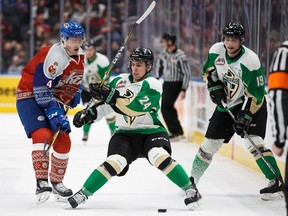 Will Warm #4 of the Edmonton Oil Kings defends the zone against Cole Fonstad #24 of the Prince Albert Raiders during the 2017 Teddy Bear Toss at Rogers Place in Edmonton on Saturday, Dec. 2, 2017.