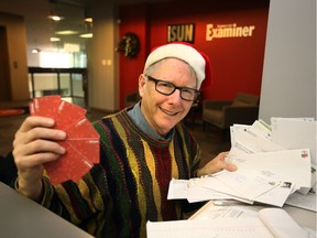 Graham Hicks, Edmonton Sun columnist and founder of the Edmonton Sun Adopt-A-Teen charity, sorts through mailed in donations for Adopt-A-Teen at the Edmonton Sun Office.
