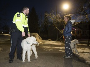 Sgt. Seamus Mastre talks to Annie Wiminga Scott in the off-leash dog park as his team launches an enforcement blitz to educate or fine dog owners who let their pets run off-leash on nearby bike paths.