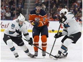Edmonton's Connor McDavid (97) is flanked by San Jose's Marcus Sorensen (20) and Joel Ward (42) during the first period of a NHL game at Rogers Place between the Edmonton Oilers and the San Jose Sharks in Edmonton, Alberta on Monday, December 18, 2017.