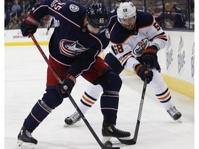 Columbus Blue Jackets' Markus Nutivaara, left, and Edmonton Oilers' Anton Slepyshev, fight for a loose puck Tuesday, Dec. 12, 2017, in Columbus, OH.