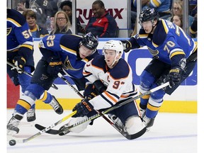 Edmonton Oilers center Connor McDavid competes for the puck against St. Louis Blues right wing Dmitrij Jaskin, left, and center Oskar Sundqvist on Nov. 21, 2017, at the Scottrade Center in St. Louis. (File)