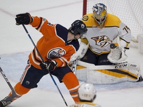 Edmonton Oilers Kris Russell (4) deflects the puck into Nashville Predators goalie Juuse Saros (74) during third period NHL action on Thursday, Dec. 14, 2017 in Edmonton.