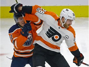 Philadelphia Flyer Claude Giroux (right) is checked by Edmonton Oiler Drake Caggiula (left) during second period NHL game action in Edmonton on Wednesday December 6, 2017.