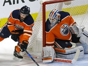 Edmonton Oilers defenceman Kris Russell, left, skates past goalie Laurent Brossoit during NHL action against the Toronto Maple Leafs in Edmonton on November 30, 2017.