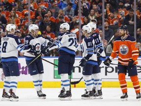 Winnipeg Jets celebrate a goal as Edmonton Oilers' Adam Larsson (6) skates past during second period NHL action in Edmonton on Sunday, December 31, 2017.