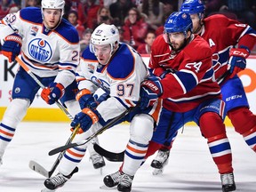 Connor McDavid #97 of the Edmonton Oilers skates the puck against Phillip Danault #24 of the Montreal Canadiens during the NHL game at the Bell Centre on February 5, 2017 in Montreal, Quebec, Canada.