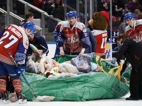 Trey Fix-Wolansky #27, Conner McDonald #37 and David Kope #20 of the Edmonton Oil Kings help collect teddy bears after Davis Koch #16 scored against the Prince Albert Raiders during the 2017 Teddy Bear Toss at Rogers Place in Edmonton on Saturday, Dec. 2, 2017. The Oil Kings lost 7-2 to the Lethbridge Hurricanes on Sunday, Dec. 3 at Rogers Place.