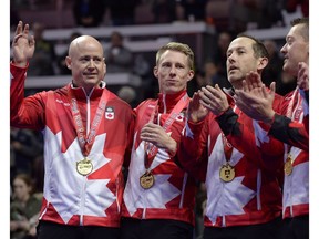 Team Koe skip Kevin Koe of Calgary, left, waves after receiving his gold medal with third Marc Kennedy, second Brent Laing and lead Ben Hebert during the 2017 Roar of the Rings Canadian Olympic Curling Trials final in Ottawa on Sunday, Dec. 10, 2017.