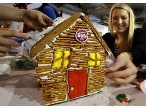 Melissa Ternavatsky works on the Edmonton Sun's winning entry for "Best in Print" is seen after judging at the Christmas Bureau of Edmonton kick off of it's 2013 goal of $1.8 million with their annual gingerbread building competition in Edmonton, Alta., on Monday Nov. 18, 2013.