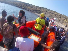 Peace River volunteers Marie Claude-Cote and Robin Differenz worked at the bow of Proactiva Open Arms' boat loading refugees fleeing to Greece in July 2017 while a volunteer with the NGO Lighthouse Relief speaks with refugees at the back of the boat.