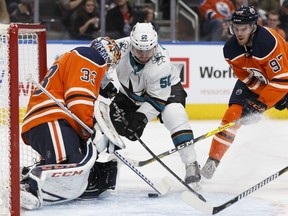 Edmonton's goaltender Cam Talbot (33) stops San Jose's Chris Tierney (50) with help from Connor McDavid (97) during the second period of a NHL game at Rogers Place between the Edmonton Oilers and the San Jose Sharks in Edmonton, Alberta on Monday, December 18, 2017.