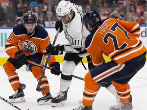 Edmonton Oilers forwards Drake Caggiula, left, and Milan Lucic, right, battle Los Angeles Kings captain Anze Kopitar during NHL action at Rogers Place on Jan. 2, 2018.