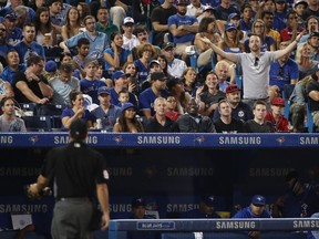 A fan reacts towards home plate umpire Ben May #97 after Kevin Pillar #11 of the Toronto Blue Jays was called out on strikes in the fourth inning against the Kansas City Royals at Rogers Centre on September 21, 2017 in Toronto. The Jays say new netting will be extended to the outfield end of each dugout. (Photo by Tom Szczerbowski/Getty Images)