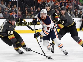Connor McDavid #97 of the Edmonton Oilers shoots against Nate Schmidt #88 of the Vegas Golden Knights as Brayden McNabb #3 of the Golden Knights defends in the first period of their game at T-Mobile Arena on January 13, 2018 in Las Vegas, Nevada.