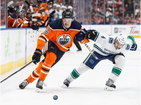 Jesse Puljujarvi #98 of the Edmonton Oilers battles against Michael Del Zotto #4 of the Vancouver Canucks at Rogers Place on January 20, 2018.