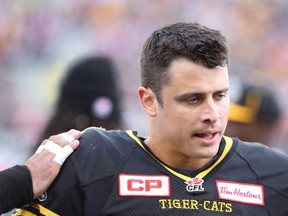 Hamilton Tiger-Cats quarterback Zach Collaros (4) gets a pat on the shoulder from a teammate after he was injured on a play during the first half of CFL football action in Hamilton, Ont. on Saturday, September 19, 2015.