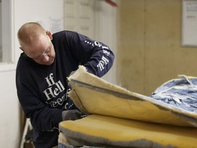 Daryl Bergen dismantles box springs for recycling at the Redemptive Developments mattress recycling facility in Edmonton on Saturday, Dec. 30, 2017.