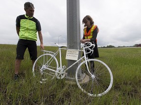 Jonathan Woelber and Coreen Shewfelt from the Edmonton Bicycle Commuters Society install a ghost bike memorial on Highway 14 just east of the Anthony Henday overpass on May 27, 2016 near Edmonton.