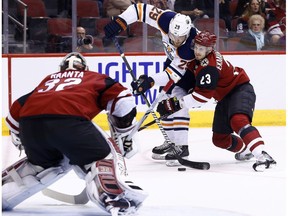 Arizona Coyotes defenseman Oliver Ekman-Larsson (23) shoves Edmonton Oilers center Leon Draisaitl (29) off his shot as Coyotes goaltender Antti Raanta (32) waits for the puck during the first period of an NHL hockey game, Friday, Jan. 12, 2018, in Glendale, Ariz.