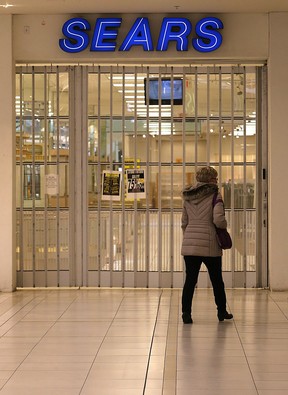 A woman walks past the shuttered Sears in the St. Vital Centre in Winnipeg on Sunday.