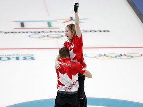 Canada's Kaitlyn Lawes and John Morris celebrate their gold medal in mixed doubles curling at the Pyeongchang Olympics on Feb. 13.