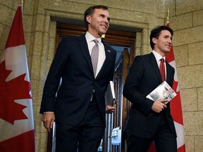 Finance Minister Bill Morneau and Prime Minister Justin Trudeau leave the Prime Minister's office holding copies of the federal budget in Ottawa, Wednesday, March 22, 2017.THE CANADIAN PRESS/Sean Kilpatrick ORG XMIT: SKP501