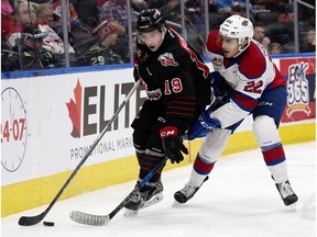 The Edmonton Oil Kings' Matthew Robertson (22) battles the Moose Jaw Warriors' Brayden Burke (19) during second period WHL action at Rogers Place in Edmonton Saturday, Jan. 6, 2018.