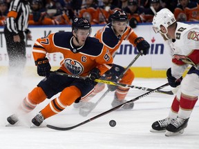 The Edmonton Oilers' Connor McDavid (97) battles the Florida Panthers' Jamie McGinn (88) during first period NHL action at Recall Place in Edmonton Monday Feb. 12, 2018.