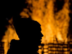 Visitors to the Silver Skate Festival watch the Fire Sculpture go up in flames in Edmonton's Hawrelak Park Sunday Feb. 18, 2018. Photo by David Bloom