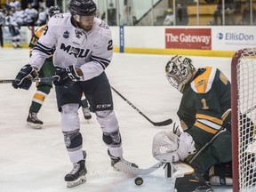 Goalie Brendan Burke of the University of Alberta Golden Bears, makes the first period save on Jamal Watson of the Mount Royal Cougars at Clare Drake Arena in Edmonton on February 24, 2018.