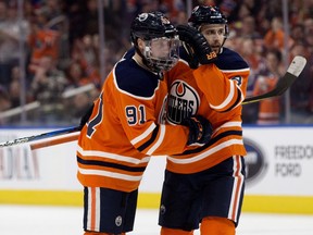 The Edmonton Oilers' Drake Caggiula (91) and Kris Russell (4) celebrate Caggiula's goal against the Florida Panthers during second period NHL action at Recall Place in Edmonton Monday Feb. 12, 2018.
