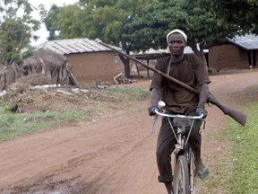 In this May 21, 2004 file photo, a member of a vigilante group in Sabon Gida patrols the town with his locally produced hunting rifle on his bicycle following attacks by Hausa Fulani herdsman at Quanpan district of Plateau State, Nigeria. (PIUS UTOMI EKPEI/AFP/Getty Images)
