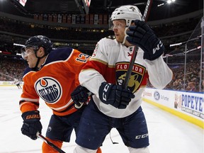 Florida Panthers defenceman Mike Matheson (19) and Edmonton Oilers left wing Michael Cammalleri (13) battle in the corner during second period NHL action in Edmonton, Alta., on Monday February 12, 2018.