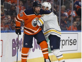 Edmonton's Patrick Maroon (19) battles Buffalo's Marco Scandella (6) during the first period of an NHL game between the Edmonton Oilers and the Buffalo Sabres at Rogers Place in Edmonton, Alberta on Tuesday, Jan. 23, 2018.