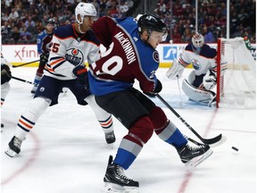 Colorado Avalanche center Nathan MacKinnon takes a shot as Edmonton Oilers defenceman Darnell Nurse and goaltender Cam Talbot defend the net in Denver on Sunday, Feb. 18, 2018.