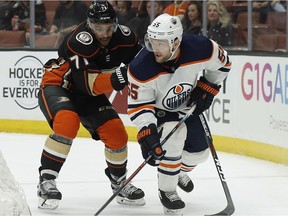 Edmonton Oilers centre Mark Letestu, right, takes the puck behind the net under pressure by Anaheim Ducks right wing J.T. Brown during the first period of an NHL hockey game in Anaheim, Calif., Friday, Feb. 9, 2018.
