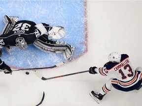 Edmonton Oilers left wing Michael Cammalleri, right, tries to get a shot in on Los Angeles Kings goaltender Jonathan Quick, center, as defenseman Dion Phaneuf helps Quick during the second period of an NHL hockey game, Saturday, Feb. 24, 2018, in Los Angeles.