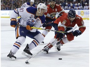 Edmonton Oilers center Connor McDavid (97) and Florida Panthers defenseman Keith Yandle (3) go for the puck during the first period of an NHL hockey game, Wednesday, Feb. 22, 2017, in Sunrise, Fla.