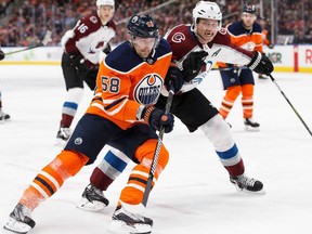Edmonton Oilers' Anton Slepyshev (58) battles against Colorado Avalanche's Erik Johnson (6) during second period NHL action in Edmonton on Thursday, Feb. 1, 2018.