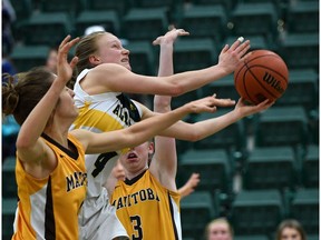 Alberta Pandas Jenna Harpe (4) will score two points and gets fouled while being covered by Manitoba Bisons Montana Kinzel (1) or Taylor Randall (3) as the Pandas advance to the Canada West playoffs defeating the Bisons 81-72 at the Saville Sports Centre in Edmonton, February 10, 2018.