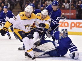 Nashville Predators' Pontus Aberg (46) and Viktor Arvidsson (33) vie for position with Toronto Maple Leafs defenceman Jake Gardiner (51) in front of a fallen Leafs goaltender Frederik Andersen (31)during first period NHL hockey action in Toronto on Wednesday, February 7, 2018.