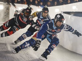 Canadian skater Derrek Coccimiglio (77) falls as he battles Canadian skater Guillaume Bouvet-Morrissette (33) and Swiss skater Kim Mueller (17) during the Red Bull Crashed Ice Ice Cross Downhill World Championship in Edmonton on March 14, 2015.