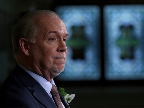 Premier John Horgan answers questions from the media following the speech from the throne in the legislative assembly in Victoria, B.C., on Tuesday, February 13, 2018. THE CANADIAN PRESS/Chad Hipolito ORG XMIT: CAH702