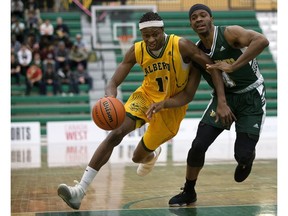 The Alberta Golden Bears' Mamadou Gueye (11) battles the UNBC Timberwolves' Jovan Leamy (4) during the men's Canada West basketball playoff quarterfinal at the Saville sports Centre, in Edmonton Friday Feb. 16, 2018. Alberta won 98-64. (David Bloom)